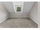 Finished attic with cozy carpeting, a dormer window overlooking greenery, and neutral paint at 625 La Placita St, Greenwood, IN 46143