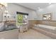 Luxurious bathroom with a step-up tub, vanity, and bright window at 625 La Placita St, Greenwood, IN 46143