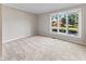 Bright bedroom featuring a large window with outside views and neutral carpeting at 625 La Placita St, Greenwood, IN 46143