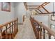 Open hallway with hardwood railings, carpet flooring, and wood-trimmed ceilings at 625 La Placita St, Greenwood, IN 46143