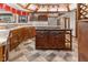 A kitchen island with a cooktop is surrounded by dark wood cabinets and custom flooring at 625 La Placita St, Greenwood, IN 46143