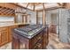 Spacious kitchen island with a cooktop, dark wood cabinets, and unique ceiling with modern appliances at 625 La Placita St, Greenwood, IN 46143