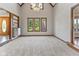 Spacious living room featuring plush carpeting, neutral walls, a chandelier and built-in shelving at 625 La Placita St, Greenwood, IN 46143
