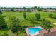 Aerial view of the pool area with a slide and mature trees, with the golf course in the background at 625 La Placita St, Greenwood, IN 46143