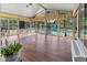 Enclosed sunroom boasts hardwood floors and expansive windows overlooking an outdoor pool area at 625 La Placita St, Greenwood, IN 46143
