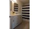Bathroom features a double vanity with modern fixtures and a blue and white striped shower curtain at 6483 Timber Walk Dr, Indianapolis, IN 46236