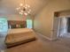 Spacious bedroom features a vaulted ceiling, stylish light fixture, and a comfortable bed with decorative pillows at 6483 Timber Walk Dr, Indianapolis, IN 46236
