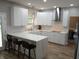 A modern kitchen with white cabinets, stainless steel appliances, and a large marble countertop island with stools at 6483 Timber Walk Dr, Indianapolis, IN 46236