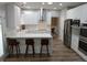 Modern kitchen with white cabinets, stainless steel appliances, island, and herringbone backsplash at 6483 Timber Walk Dr, Indianapolis, IN 46236
