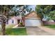Charming brick home featuring an attached two-car garage, manicured lawn, and mature trees at 6640 Chipping Ct, Indianapolis, IN 46268