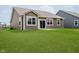 Back exterior of home with brown vinyl siding, sliding glass door, and large grassy yard at 6644 Aberdeen Dr, McCordsville, IN 46055