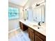 Bright bathroom features dual sinks, modern lighting, large mirrors, and wood cabinets at 6839 Antelope Dr, Indianapolis, IN 46278