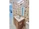 Charming bathroom featuring vintage wallpaper, updated vanity with a bright sink and toilet at 6839 Antelope Dr, Indianapolis, IN 46278