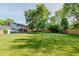 Lush green backyard featuring a well-manicured lawn, mature trees, and a glimpse of the home at 8201 Castle Dr, Indianapolis, IN 46256