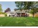 Backyard view with well-maintained lawn, mature trees, a patio, and a glimpse of the house at 8201 Castle Dr, Indianapolis, IN 46256