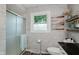 Well-lit bathroom features a glass shower, modern toilet, and grey tile at 8201 Castle Dr, Indianapolis, IN 46256