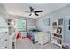 Charming bedroom with a ceiling fan, adorned with a cheerful blue and floral bedspread, and a white desk at 8201 Castle Dr, Indianapolis, IN 46256