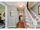 Inviting hallway leading to the staircase, featuring elegant decor and warm lighting at 8201 Castle Dr, Indianapolis, IN 46256