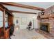 Inviting living room with a brick fireplace and bright windows and wood beam ceilings at 8201 Castle Dr, Indianapolis, IN 46256