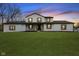 Charming two-story white home featuring a lush green lawn, a new roof and contrasting black and wooden accents at 8315 N Payne Rd, Indianapolis, IN 46268