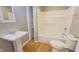 Bathroom featuring a vanity sink, toilet, and a shower-tub combo with built-in shelving at 8336 S Belmont Ave, Indianapolis, IN 46217