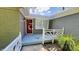The home has a covered front porch and red door with gray painted brick at 8336 S Belmont Ave, Indianapolis, IN 46217