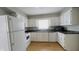 Kitchen features white appliances and cabinetry, contrasting countertops, and natural lighting at 8336 S Belmont Ave, Indianapolis, IN 46217