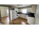 Bright kitchen featuring white cabinets, black countertops, and modern appliances with wood-look floor at 8336 S Belmont Ave, Indianapolis, IN 46217