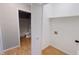 Utility room with wood look flooring with a view to bathroom with toilet and shower at 8336 S Belmont Ave, Indianapolis, IN 46217
