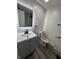 Neutral bathroom with modern vanity, toilet, and dark, matte-black accents and towel rack at 8434 Meadowlark Dr, Indianapolis, IN 46226