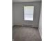 Simple bedroom with plush carpet, white walls, a window, and minimalist decor at 8434 Meadowlark Dr, Indianapolis, IN 46226