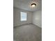 Spacious bedroom with plush carpet, white walls, a window, and minimalist decor at 8434 Meadowlark Dr, Indianapolis, IN 46226