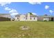 Home exterior showcasing the spacious back yard, complete with a stone fire pit area at 8778 N Deer Crossing Blvd, McCordsville, IN 46055