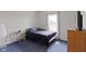 A cozy bedroom with blue carpet, a bed, window, and matching blue comforter at 8778 N Deer Crossing Blvd, McCordsville, IN 46055