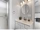 Bathroom with a framed round mirror and an adjacent walk-in shower at 914 N Alabama St, Indianapolis, IN 46202
