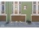 A close view of painted townhome garages featuring bay windows above and green brick facade at 914 N Alabama St, Indianapolis, IN 46202