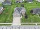 Expansive aerial view of a brick two-story home with a well-manicured lawn and mature trees at 1035 White Oak Dr, Plainfield, IN 46168