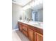 Bright bathroom featuring double sinks, wooden cabinets, and a large mirror with decorative lighting at 1035 White Oak Dr, Plainfield, IN 46168