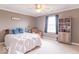 Bright bedroom with ceiling fan featuring a comfortable bed, sitting chair, and bookshelves at 1035 White Oak Dr, Plainfield, IN 46168