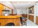 An inviting home bar with a wooden counter, seating, and ample storage at 10518 Courageous Dr, Indianapolis, IN 46236