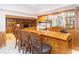 Finished basement bar area with a long counter, seating, and a view of the fireplace at 10518 Courageous Dr, Indianapolis, IN 46236