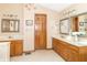 Bathroom featuring double vanity, framed mirrors, wooden cabinets, and tiled floors at 10518 Courageous Dr, Indianapolis, IN 46236