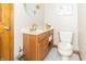 A charming powder room with a wood vanity, brushed gold faucet, and a decorative mirror at 10518 Courageous Dr, Indianapolis, IN 46236