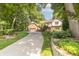 Charming two-story home with lush landscaping and a long driveway, surrounded by mature trees at 10518 Courageous Dr, Indianapolis, IN 46236
