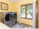 Bright laundry room featuring side-by-side washer and dryer and a window view of the yard at 10518 Courageous Dr, Indianapolis, IN 46236