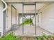 Back porch with concrete floor and metal beams, providing access to the yard and back door at 1201 Arrow Ave, Anderson, IN 46016