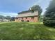 Spacious backyard featuring a well-maintained lawn and a classic two-story home with brick and siding at 1289 Woodcreek Dr, Greenwood, IN 46142