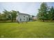 Spacious backyard features a lush lawn, mature trees, and a fire pit area at 13074 Lansdowne Dr, Fishers, IN 46038