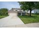 Traditional home featuring a two-car garage, lush lawn, mature tree, and welcoming front entrance at 13074 Lansdowne Dr, Fishers, IN 46038