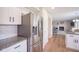 Well-lit kitchen with stainless steel refrigerator, white cabinets, granite countertops, and wood-look flooring at 13074 Lansdowne Dr, Fishers, IN 46038